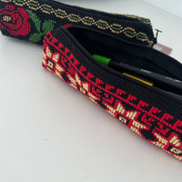 Embroidered pencil case with floral patterns on a white background