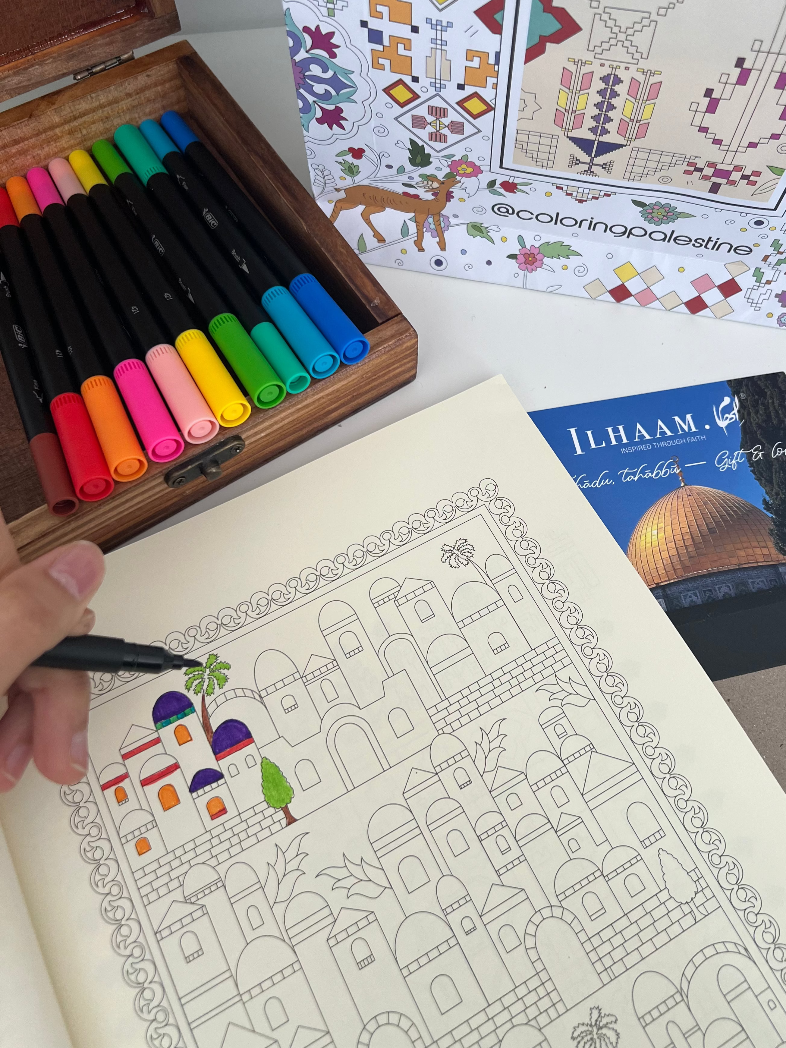 Coloring book with a completed page and markers on a table