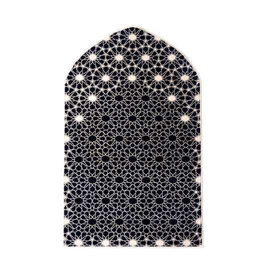 Islamic prayer rug with arched mihrab shape and black and white geometric pattern on a white background