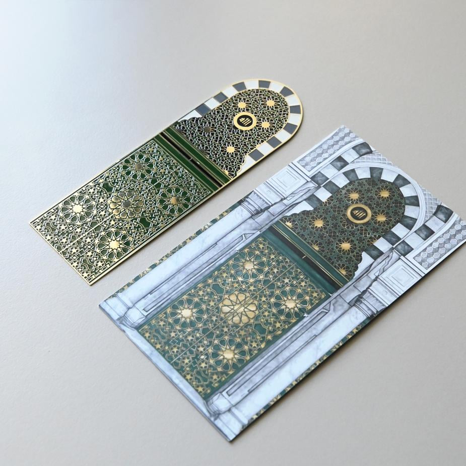 Gold metal bookmark inspired by the door of the Grand Makkah Mosque displayed on its matching illustrated backing card