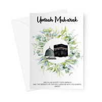 Islamic Umrah greeting card designed by Ilhaam featuring the Kaaba and Masjid an-Nabawi surrounded by green foliage with an “Umrah Mubarak” message
