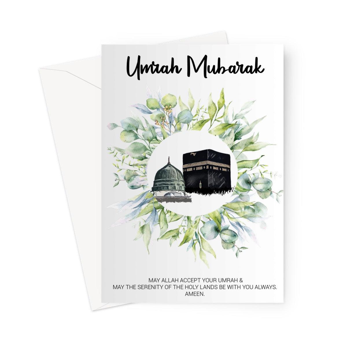 Islamic Umrah greeting card designed by Ilhaam featuring the Kaaba and Masjid an-Nabawi surrounded by green foliage with an “Umrah Mubarak” message
