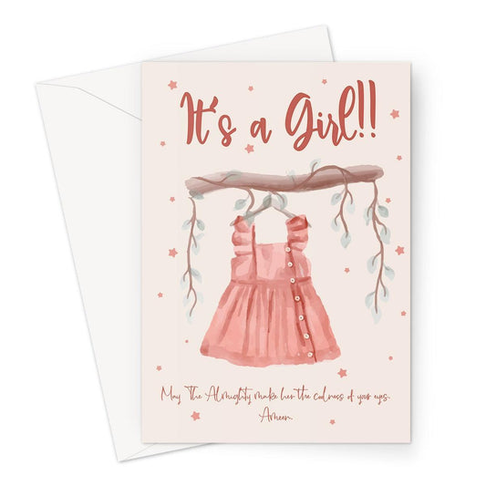 Islamic baby girl congratulations greeting card featuring the message “It’s a Girl” with a dua asking Allah to make her the coolness of her parents’ eyes, illustrated with a soft pink dress design, designed by Ilhaam.
